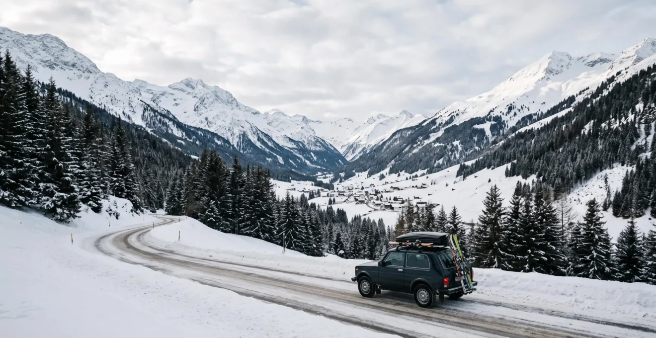 Voiture chargée de skis et de bagages sur une route de montagne enneigée menant vers une station alpine, illustrant le covoiturage vers La Clusaz