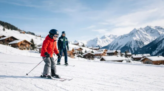 Jeune enfant skieur accompagné par un moniteur sur une piste ensoleillée des Alpes, symbole de la progression en cours ESF