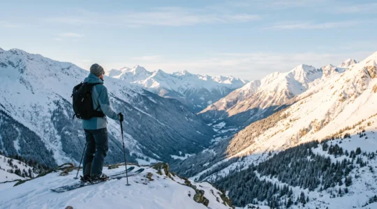 Skieur observant depuis une crête plusieurs pistes aux conditions de neige différentes dans les Alpes